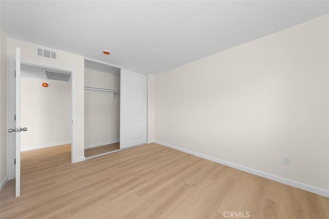 unfurnished bedroom featuring a closet and light hardwood / wood-style flooring