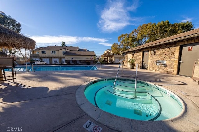 view of swimming pool with a patio area and a hot tub