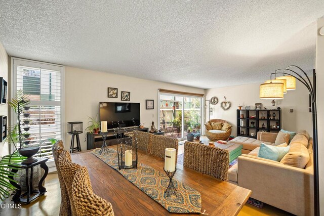 dining area featuring wood-type flooring and a textured ceiling