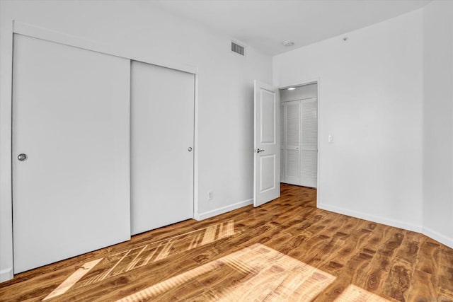 unfurnished bedroom with a closet and wood-type flooring