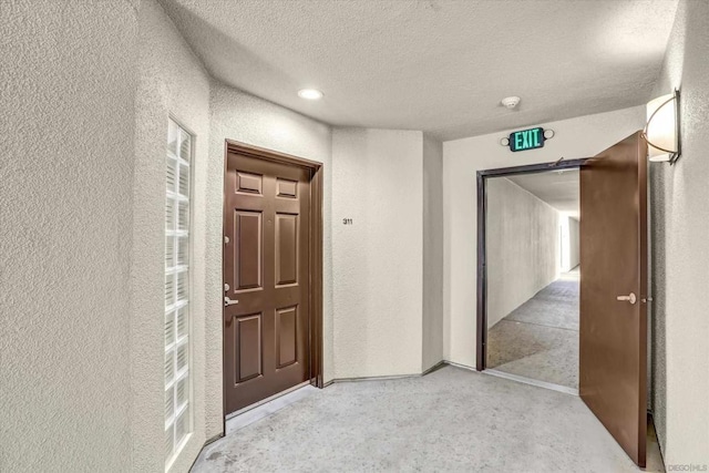 hall featuring a textured ceiling