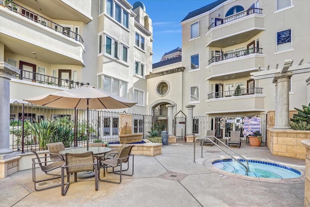 view of swimming pool featuring a community hot tub and a patio