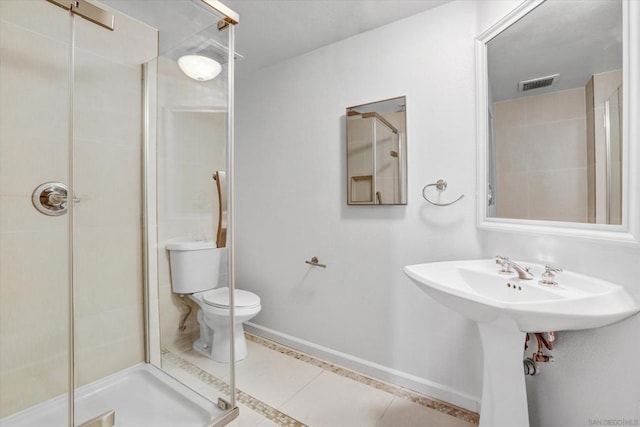 bathroom with toilet, a shower, and tile patterned floors