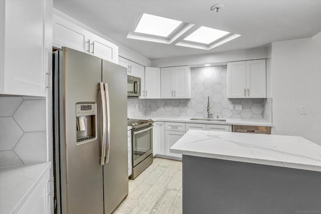 kitchen with stainless steel appliances, white cabinetry, and sink