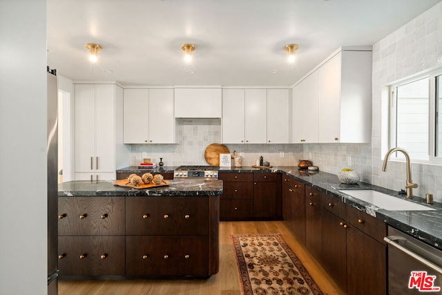 kitchen featuring dark stone countertops, dark brown cabinets, dishwasher, white cabinets, and sink