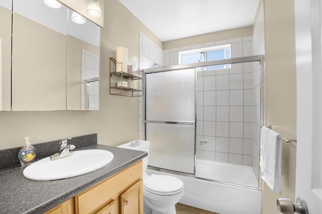 full bathroom featuring combined bath / shower with glass door, vanity, toilet, and hardwood / wood-style floors