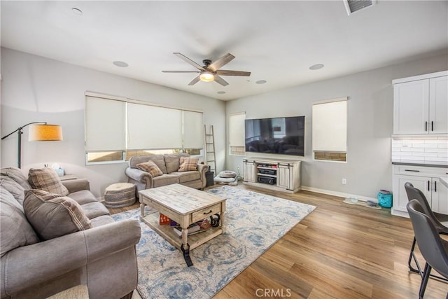 living room with light wood-type flooring and ceiling fan