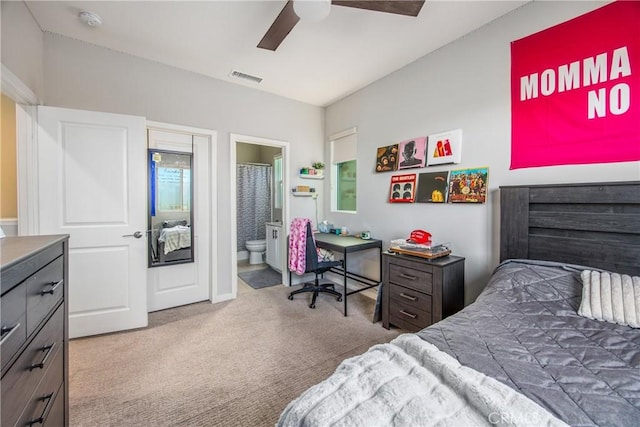 bedroom with ceiling fan, ensuite bath, and carpet floors