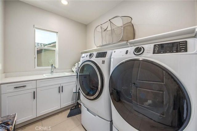 clothes washing area featuring cabinets, separate washer and dryer, light tile patterned flooring, and sink