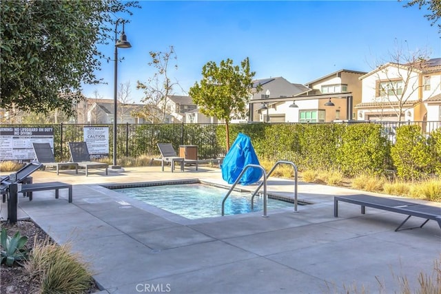 view of swimming pool featuring a hot tub and a patio