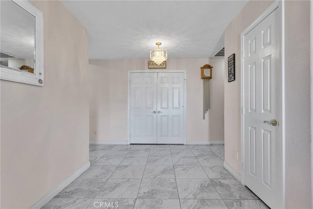 corridor featuring an inviting chandelier