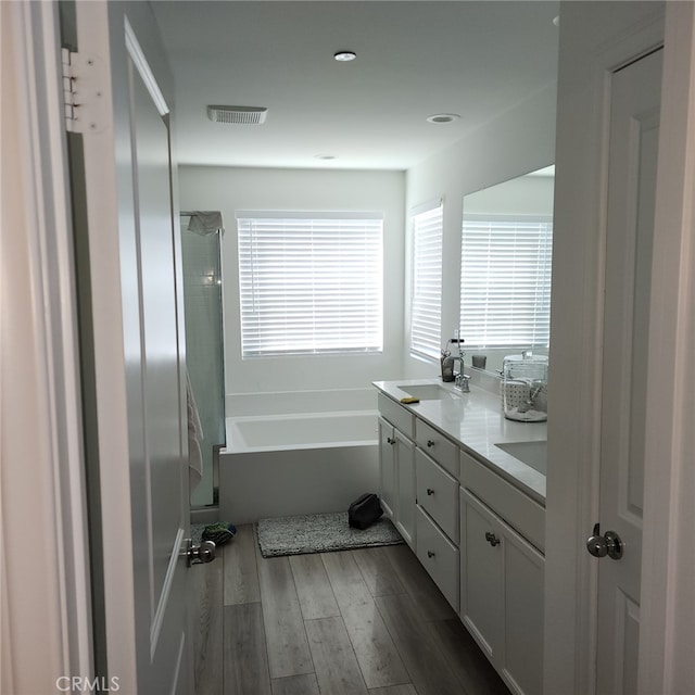 bathroom featuring hardwood / wood-style floors, vanity, and independent shower and bath