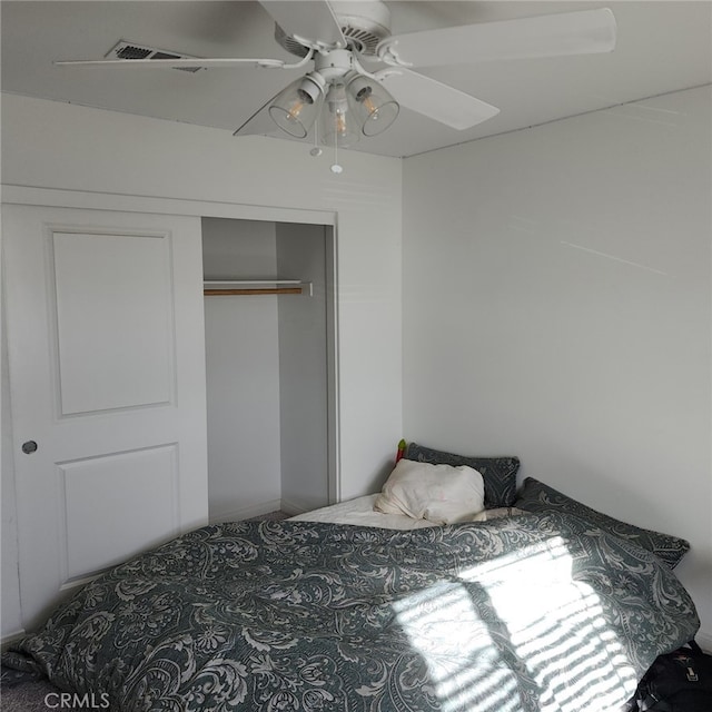 bedroom with ceiling fan and a closet