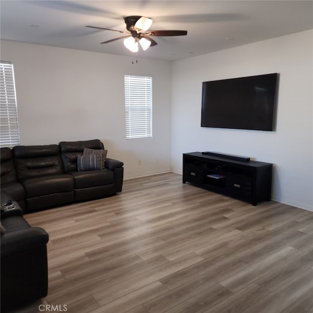 living room featuring light hardwood / wood-style floors and ceiling fan