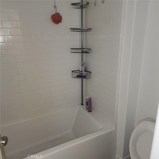 bathroom featuring toilet and tiled shower / bath combo