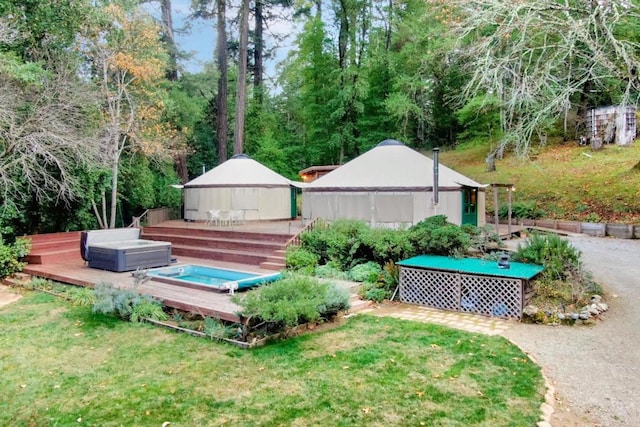 view of yard featuring a covered hot tub, a wooden deck, and a gazebo