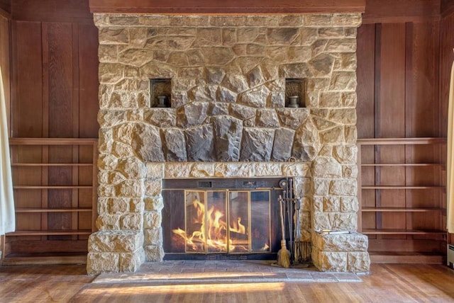 interior details with built in features, a fireplace, wood-type flooring, and wooden walls