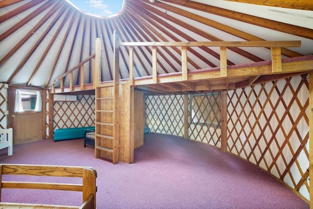 unfurnished bedroom with lofted ceiling and carpet