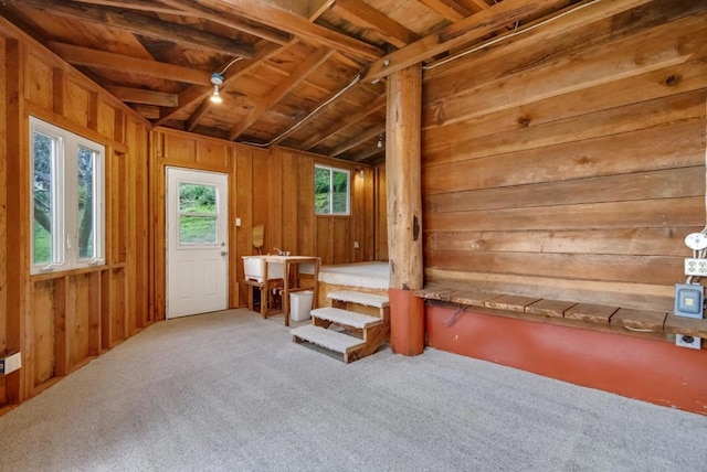 miscellaneous room with carpet floors, lofted ceiling with beams, wood walls, and wooden ceiling