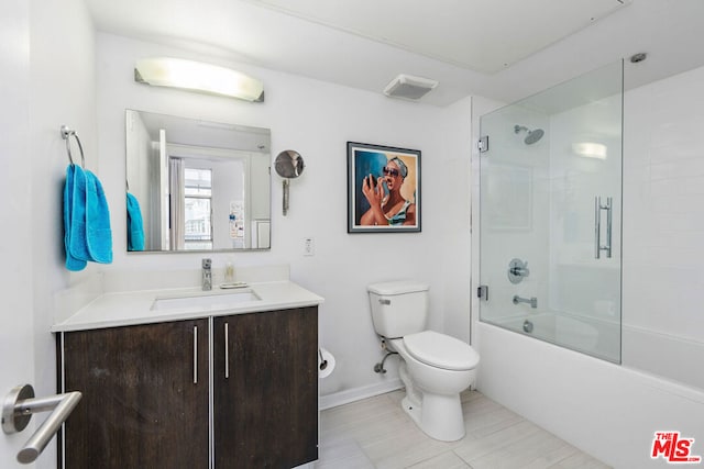 full bathroom with toilet, tile patterned flooring, enclosed tub / shower combo, and vanity