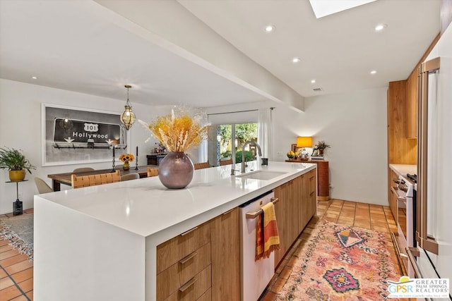 kitchen featuring light tile patterned flooring, appliances with stainless steel finishes, a large island, and sink