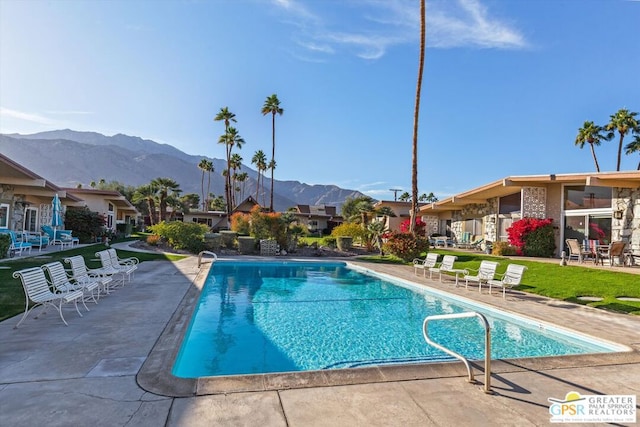 view of swimming pool featuring a patio area and a mountain view