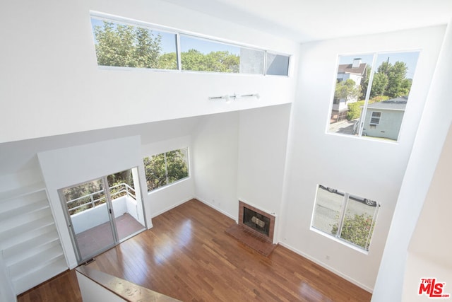 unfurnished living room with plenty of natural light and dark hardwood / wood-style flooring