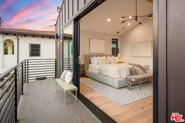 tiled bedroom with vaulted ceiling and a chandelier