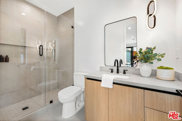 bathroom featuring toilet, vanity, and walk in shower