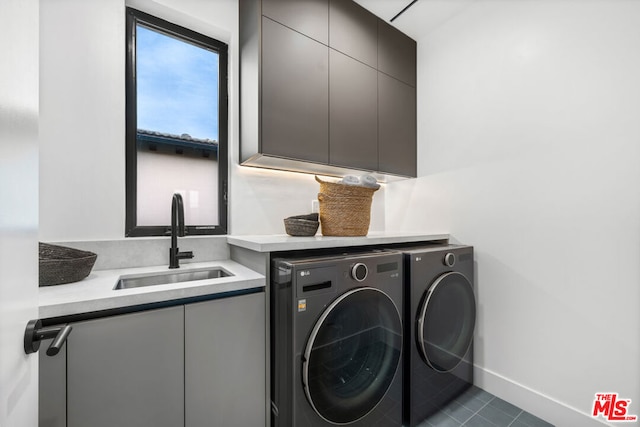 laundry room with cabinets, independent washer and dryer, dark tile patterned flooring, and sink