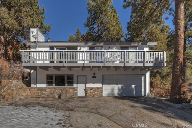 rear view of property with a garage and a wooden deck