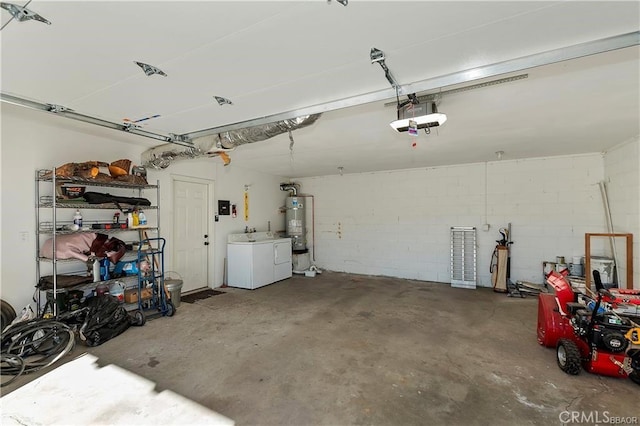 garage featuring a garage door opener, washing machine and clothes dryer, and gas water heater