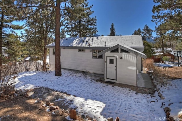 view of snow covered back of property