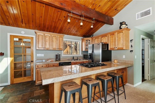 kitchen with black appliances, sink, kitchen peninsula, lofted ceiling with beams, and a breakfast bar