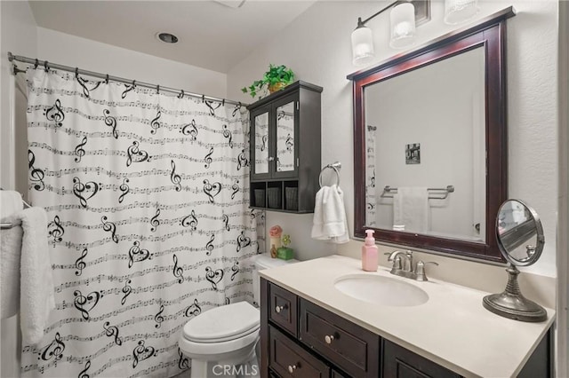 bathroom with curtained shower, vanity, and toilet