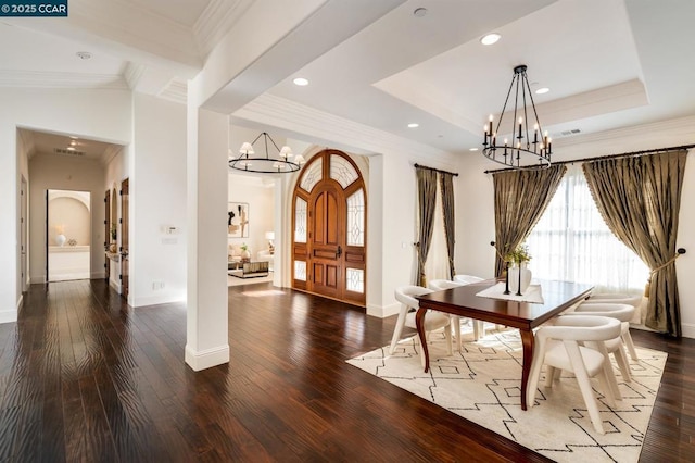 dining space featuring an inviting chandelier, dark hardwood / wood-style flooring, crown molding, and a tray ceiling