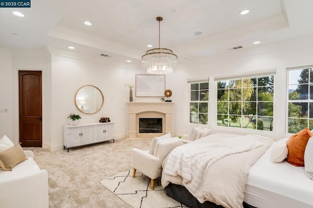 carpeted bedroom featuring an inviting chandelier, crown molding, and a tray ceiling