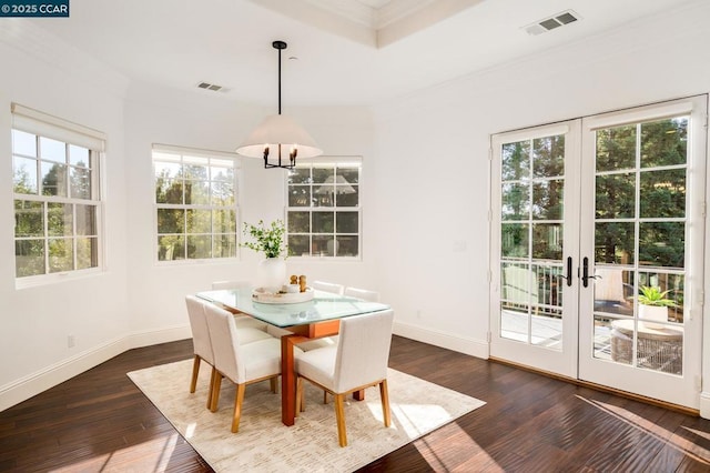 dining area featuring dark wood-type flooring, ornamental molding, and french doors