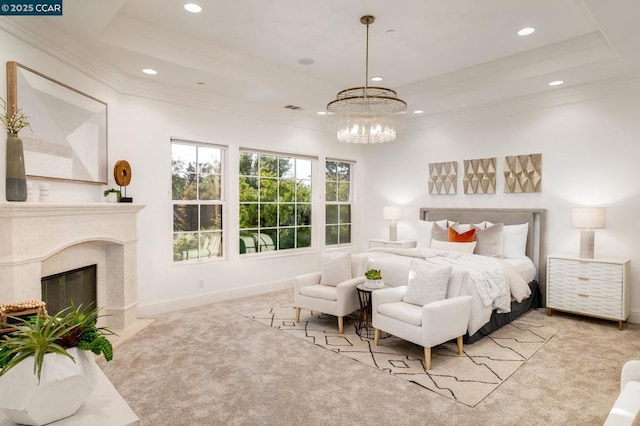 bedroom with an inviting chandelier, a tray ceiling, light carpet, and a fireplace