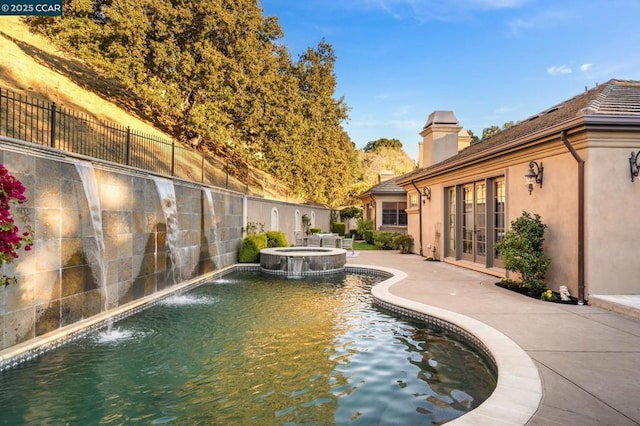 view of pool with an in ground hot tub and pool water feature