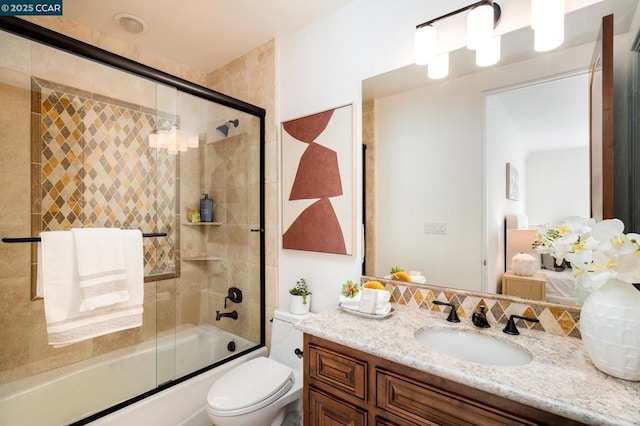 full bathroom with toilet, combined bath / shower with glass door, and vanity