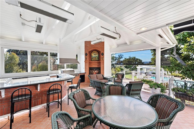 view of patio with a bar, a fireplace, and grilling area