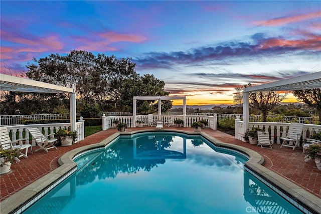 pool at dusk with a patio area