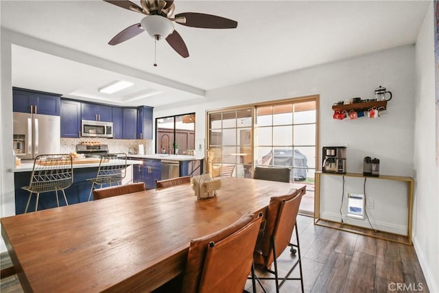 dining area featuring dark wood-type flooring, sink, and ceiling fan