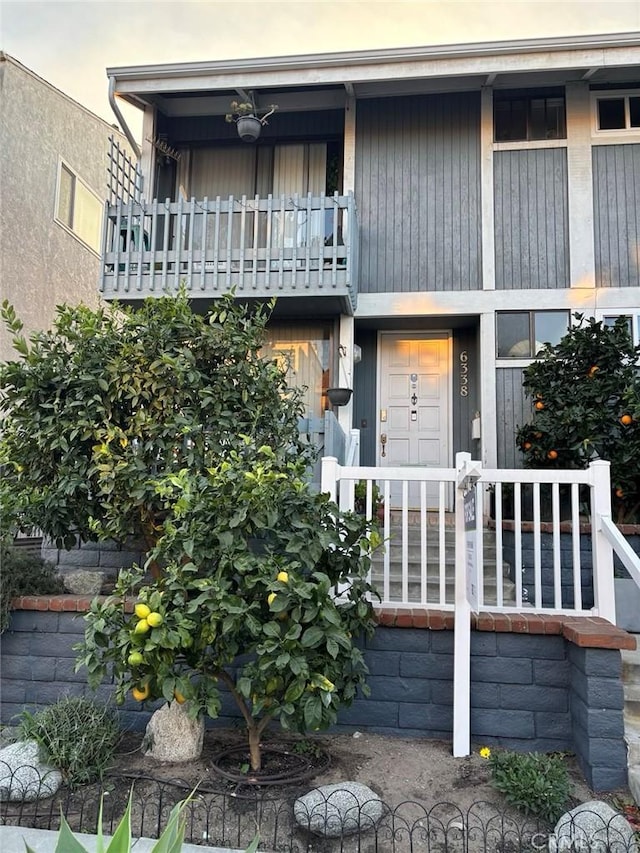 exterior entry at dusk featuring a balcony