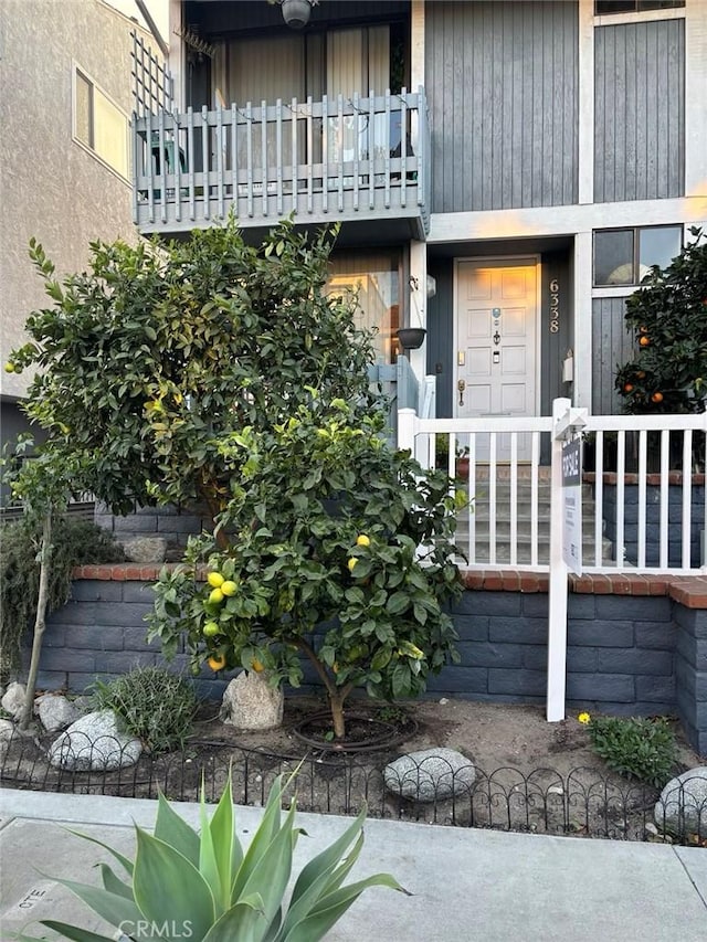 view of exterior entry featuring a balcony