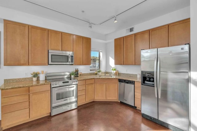 kitchen with light stone counters, sink, and stainless steel appliances