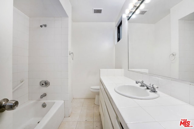 full bathroom featuring toilet, tiled shower / bath, tile patterned floors, and vanity