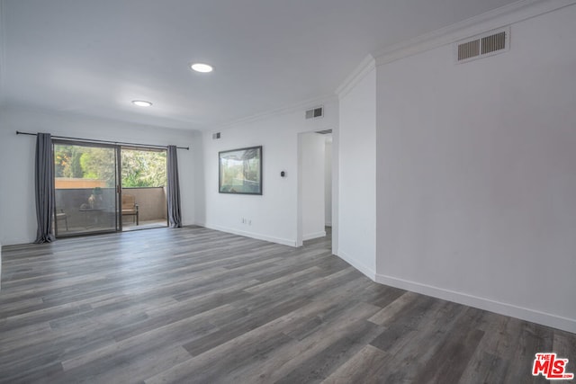 spare room featuring ornamental molding and dark hardwood / wood-style flooring