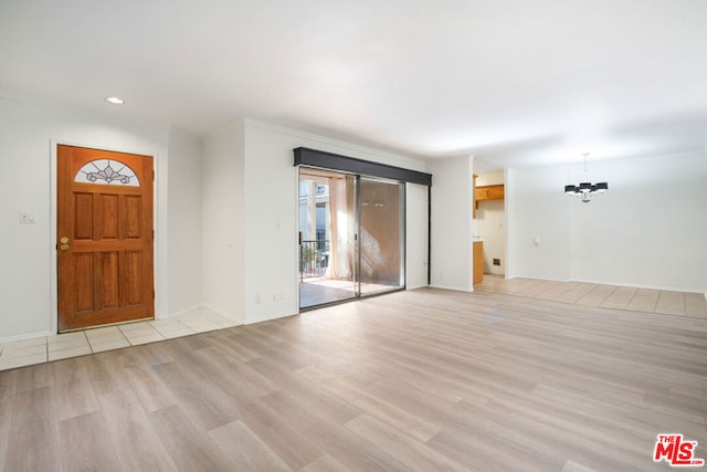 foyer with light wood-type flooring and a chandelier